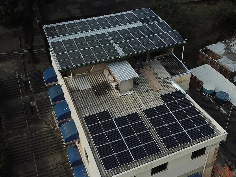 Vista aérea de prédio comercial em Canoinhas com módulos fotovoltaicos sobre o barracão e a laje dos fundos