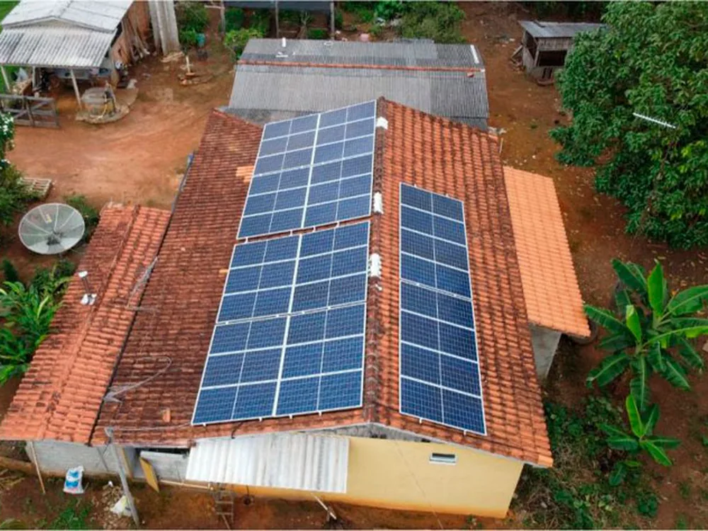 Vista aérea de casa rural em Itaiópolis com módulos fotovoltaicos distribuídos em duas águas do telhado de cerâmica